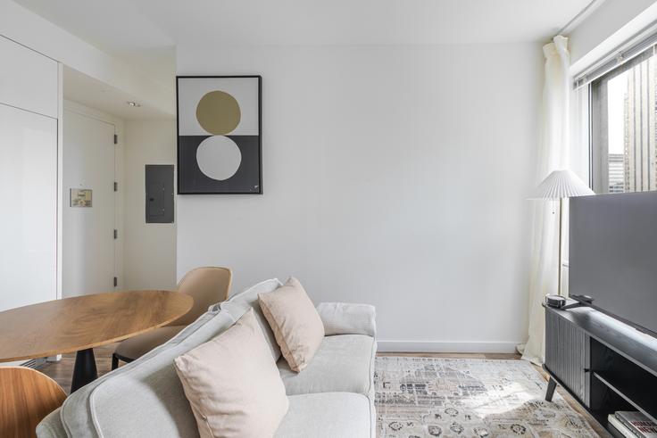 Elegante sala de estar con mobiliario moderno en un apartamento en Cassa en Manhattan, New York