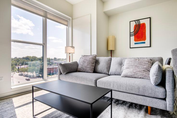 Sala de estar elegantemente projetada com móveis modernos em um apartamento no The Marke of Elmhurst em Elmhurst, Elmhurst