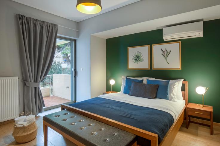 Quarto principal aconchegante com cama grande, iluminação suave e móveis elegantes em um apartamento mobiliado no Nisous em South Athens, Athens