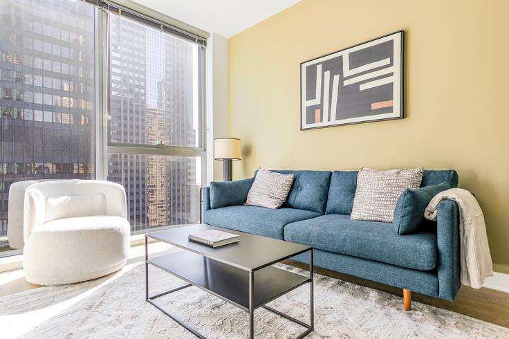 Sala de estar elegantemente projetada com móveis modernos em um apartamento no Mila em Chicago, Chicago Sala de estar elegantemente projetada com móveis modernos em um apartamento no Mila em Chicago, Chicago