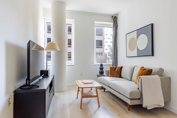 Elegante sala de estar con mobiliario moderno en un apartamento en Cassa en Manhattan, New York