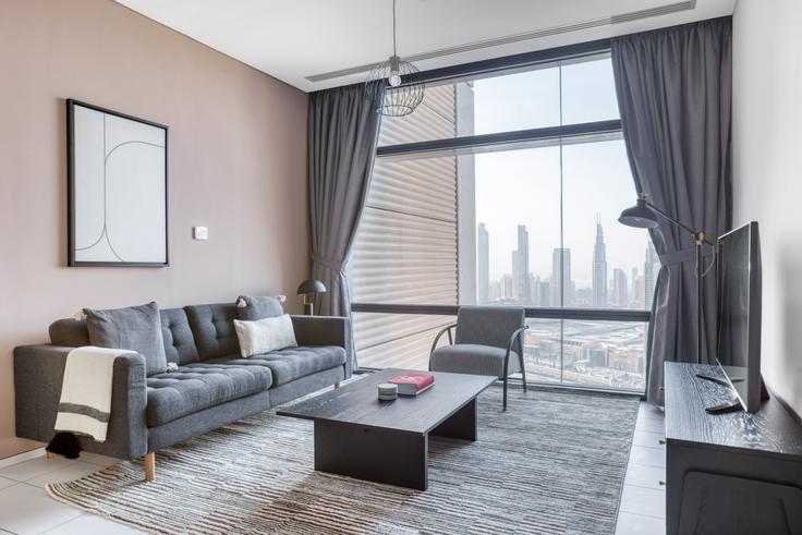 Sala de estar chique com design minimalista de um apartamento mobiliado em Index Tower, Dubai