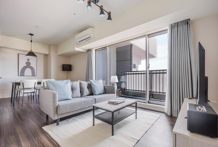 Elegante sala de estar con mobiliario moderno en un apartamento en Frontier Shinjuku Tower en Shinjuku City, Tokyo Elegante sala de estar con mobiliario moderno en un apartamento en Frontier Shinjuku Tower en Shinjuku City, Tokyo