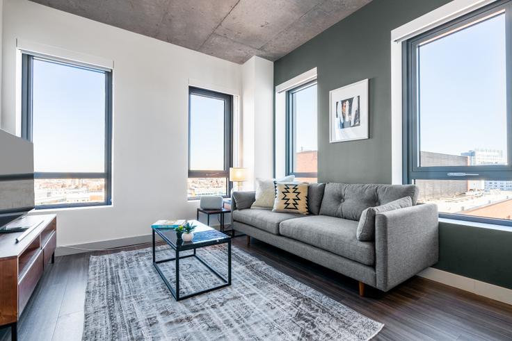 Elegantly designed living room with modern furnishings in an apartment at Proto in Kendall Square, Boston