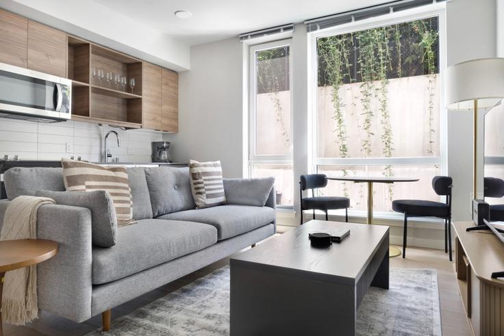 Elegante sala de estar con mobiliario moderno en un apartamento en Ion Queen Anne en Seattle, Seattle Elegante sala de estar con mobiliario moderno en un apartamento en Ion Queen Anne en Seattle, Seattle