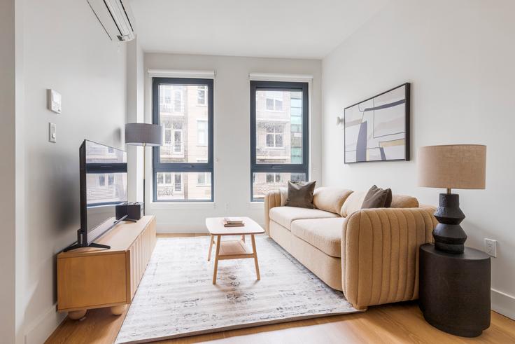 Sala de estar elegantemente projetada com móveis modernos em um apartamento no Casa Hope em Brooklyn, New York Sala de estar elegantemente projetada com móveis modernos em um apartamento no Casa Hope em Brooklyn, New York