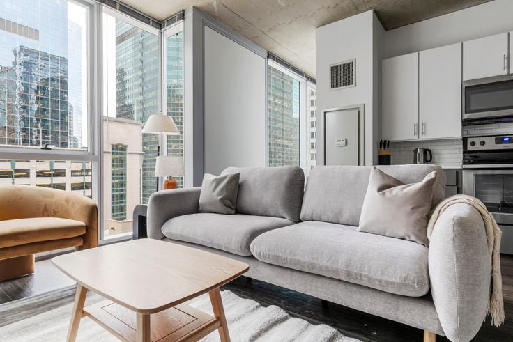 Sala de estar elegantemente projetada com móveis modernos em um apartamento no Linea em Chicago, Chicago Sala de estar elegantemente projetada com móveis modernos em um apartamento no Linea em Chicago, Chicago