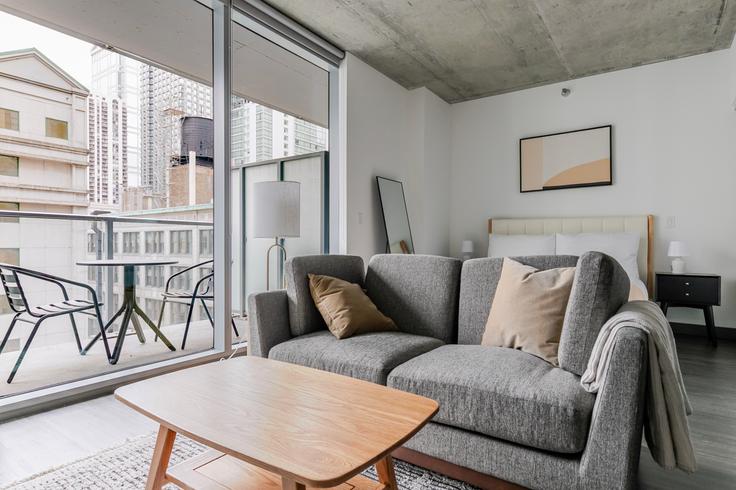Sala de estar elegantemente projetada com móveis modernos em um apartamento no Parkline em Chicago, Chicago Sala de estar elegantemente projetada com móveis modernos em um apartamento no Parkline em Chicago, Chicago