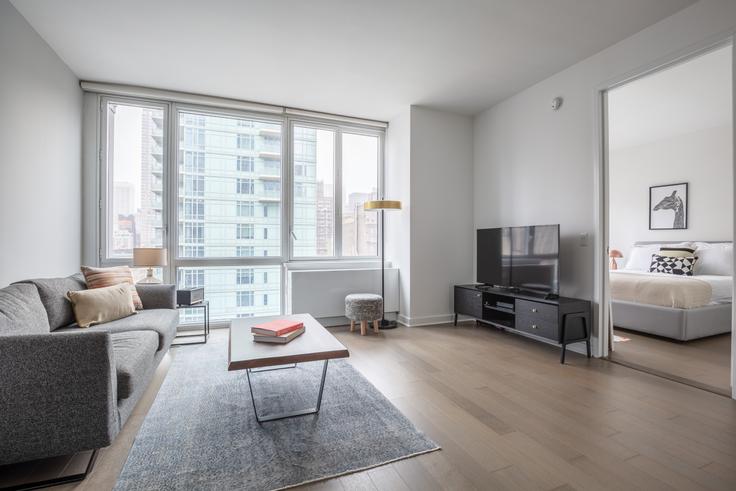 Salle de séjour élégante avec mobilier moderne dans un appartement à The Dylan à Manhattan, New York Salle de séjour élégante avec mobilier moderne dans un appartement à The Dylan à Manhattan, New York