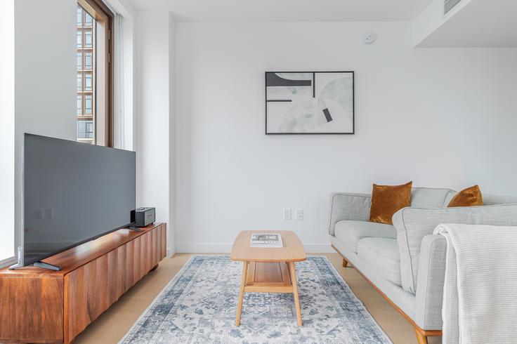 Elegante sala de estar con mobiliario moderno en un apartamento en Three Williamsburg Wharf en Brooklyn, New York Elegante sala de estar con mobiliario moderno en un apartamento en Three Williamsburg Wharf en Brooklyn, New York