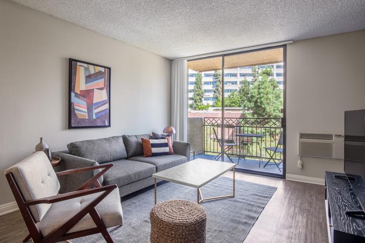 Elegantly designed living room with modern furnishings in an apartment at Ariel Court in Westwood, Los Angeles