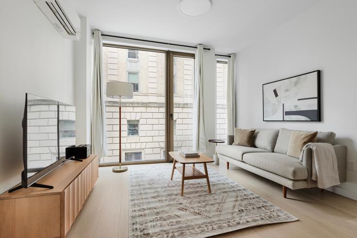 Brooklyn, New York 소재 Modavie Residences 유닛에 마련된, 현대적인 가구로 꾸며진 우아한 디자인의 거실