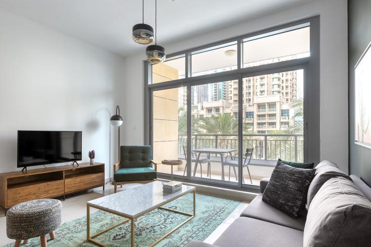 Elegante sala de estar con mobiliario moderno en un apartamento en Claren Towers en Claren, Dubai