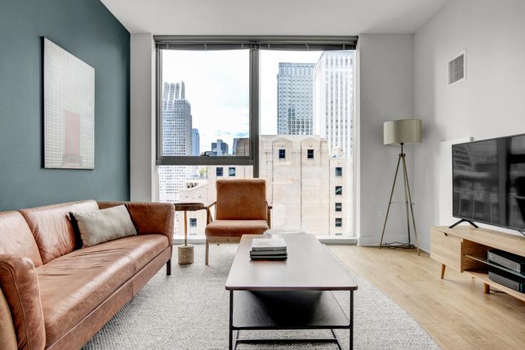 Elegante sala de estar con mobiliario moderno en un apartamento en Mila en The Loop, Chicago