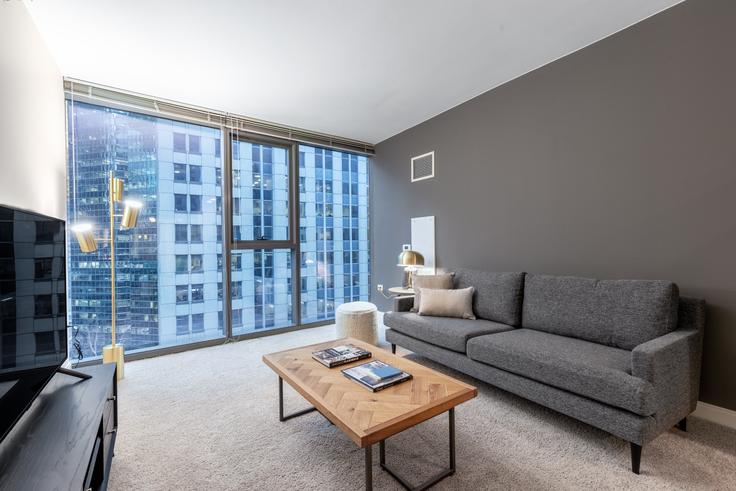 Elegantly designed living room with modern furnishings in an apartment at Lake & Wells Apartments in The Loop, Chicago