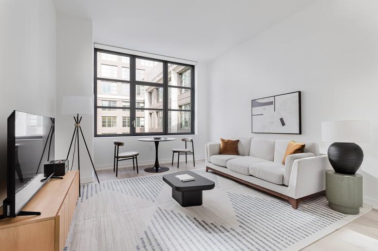 Sala de estar elegantemente projetada com móveis modernos em um apartamento no Magnolia Dumbo em Brooklyn, New York Sala de estar elegantemente projetada com móveis modernos em um apartamento no Magnolia Dumbo em Brooklyn, New York