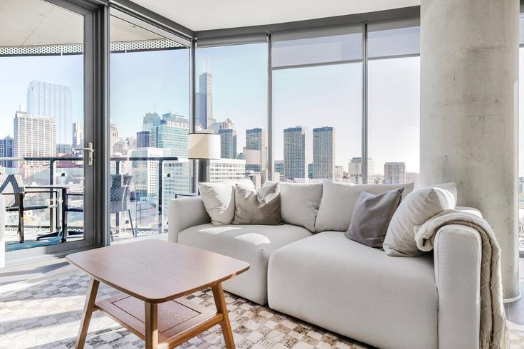 Sala de estar elegantemente projetada com móveis modernos em um apartamento no The Parker em Chicago, Chicago Sala de estar elegantemente projetada com móveis modernos em um apartamento no The Parker em Chicago, Chicago
