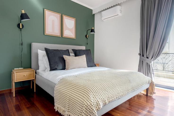 Quarto principal aconchegante com cama grande, iluminação suave e móveis elegantes em um apartamento mobiliado no Ermou III em South Athens, Athens