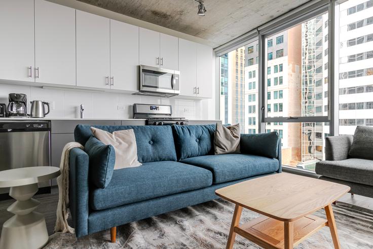 Sala de estar elegantemente projetada com móveis modernos em um apartamento no Parkline em Chicago, Chicago Sala de estar elegantemente projetada com móveis modernos em um apartamento no Parkline em Chicago, Chicago