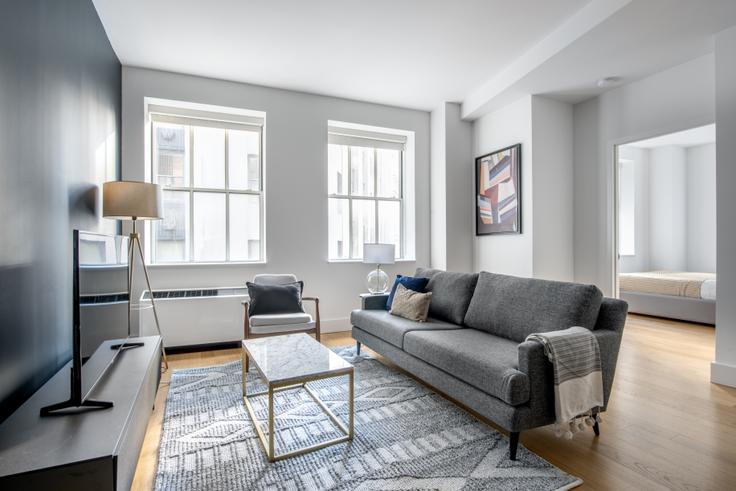Sala de estar elegantemente projetada com móveis modernos em um apartamento no 63/67 wall street em Manhattan, New York Sala de estar elegantemente projetada com móveis modernos em um apartamento no 63/67 wall street em Manhattan, New York