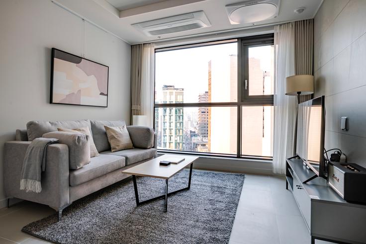 Sala de estar elegantemente projetada com móveis modernos em um apartamento no Hillstate Namsan 102 APT em Jung District, Seoul Sala de estar elegantemente projetada com móveis modernos em um apartamento no Hillstate Namsan 102 APT em Jung District, Seoul