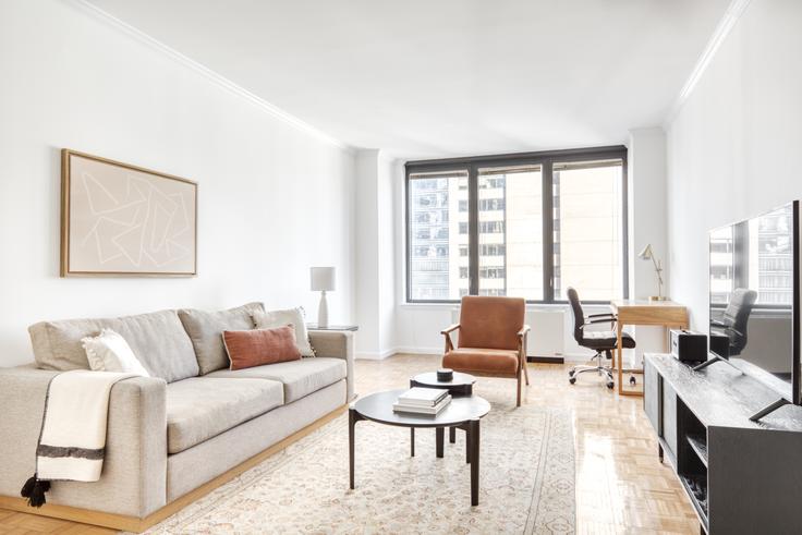 Elegante sala de estar con mobiliario moderno en un apartamento en 150 East 57th Street en Midtown East, New York