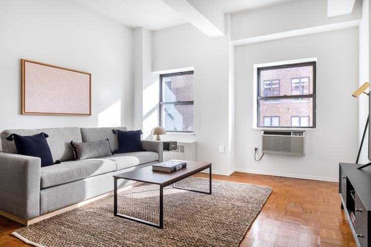 Elegantly designed living room with modern furnishings in an apartment at Sloane Chelsea in Hudson Yards, New York