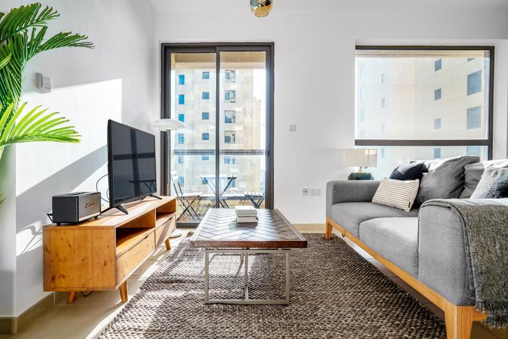 Sala de estar chique com design minimalista de um apartamento mobiliado em Bahar, Dubai