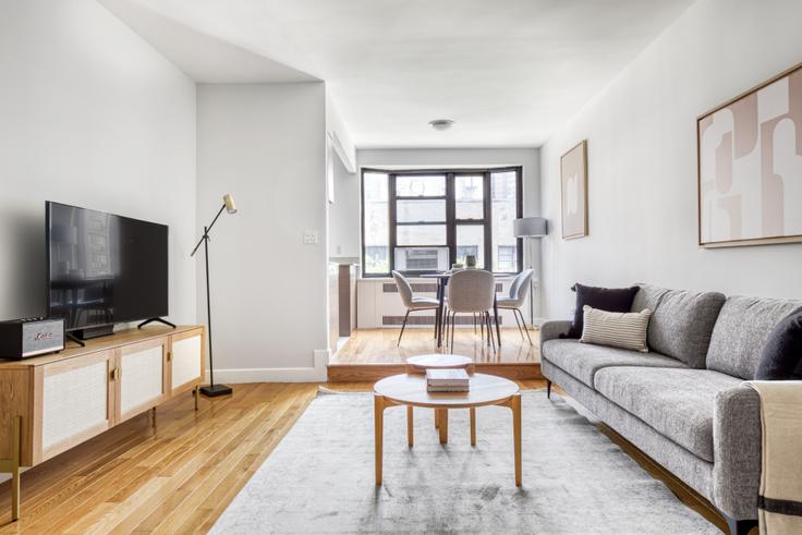 Salle de séjour élégante avec mobilier moderne dans un appartement à Stonehenge 61 à Manhattan, New York Salle de séjour élégante avec mobilier moderne dans un appartement à Stonehenge 61 à Manhattan, New York