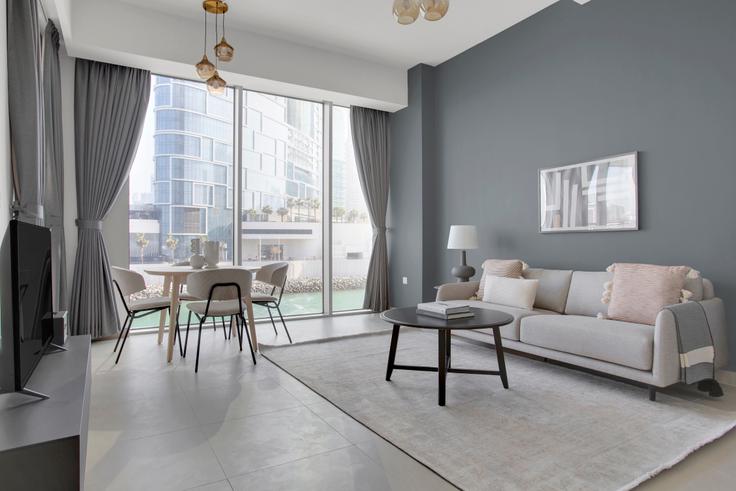 Elegante sala de estar con mobiliario moderno en un apartamento en 52|42 Tower 1 en 52|42 Tower, Dubai