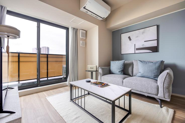 Elegante sala de estar con mobiliario moderno en un apartamento en THE PARK CROSS ICHIGAYA HARAIKATAMACHI en Shinjuku City, Tokyo