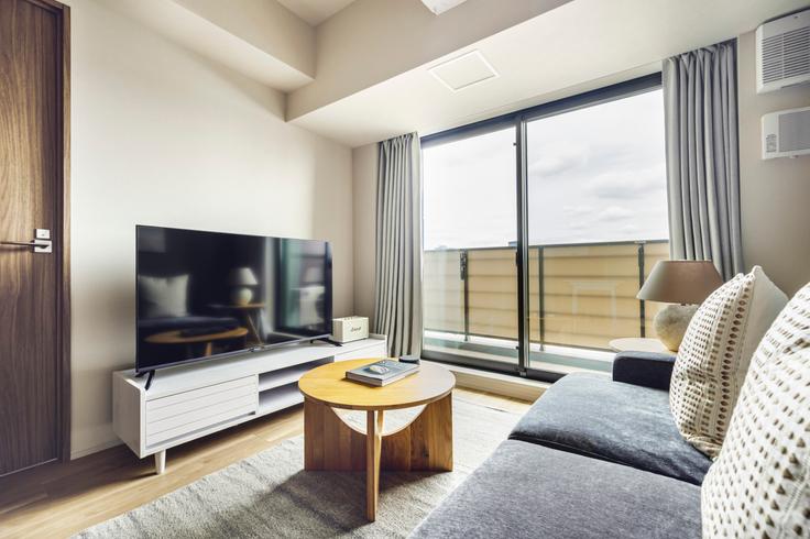 Sala de estar elegantemente projetada com móveis modernos em um apartamento no THE PARK CROSS ICHIGAYA HARAIKATAMACHI em Shinjuku City, Tokyo