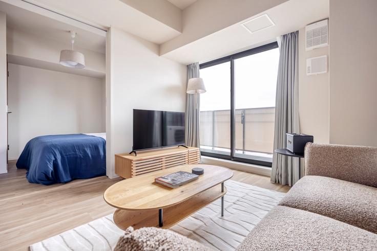 Elegante sala de estar con mobiliario moderno en un apartamento en THE PARK CROSS ICHIGAYA HARAIKATAMACHI en Shinjuku City, Tokyo