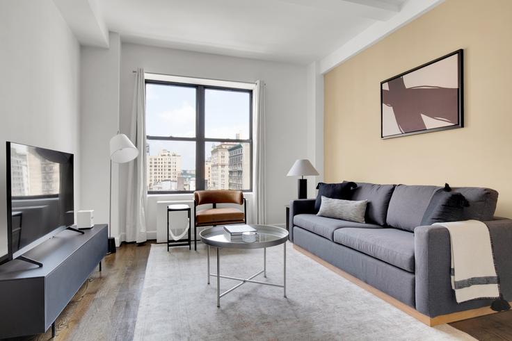 Sala de estar elegantemente projetada com móveis modernos em um apartamento no The Greystone em Manhattan, New York Sala de estar elegantemente projetada com móveis modernos em um apartamento no The Greystone em Manhattan, New York