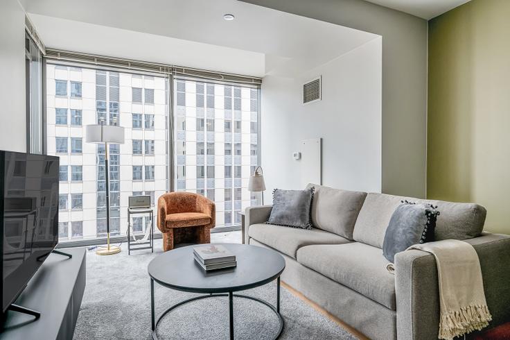 Elegantly designed living room with modern furnishings in an apartment at Lake & Wells Apartments in The Loop, Chicago