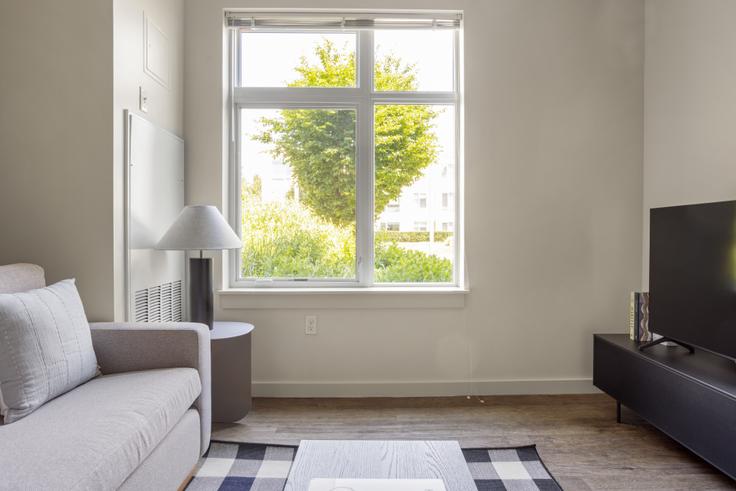 Sala de estar elegantemente projetada com móveis modernos em um apartamento no Chroma em Cambridge, Cambridge Sala de estar elegantemente projetada com móveis modernos em um apartamento no Chroma em Cambridge, Cambridge
