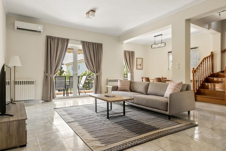 Sala de estar elegantemente projetada com móveis modernos em um apartamento no Dimokratias III em South Athens, Athens Sala de estar elegantemente projetada com móveis modernos em um apartamento no Dimokratias III em South Athens, Athens