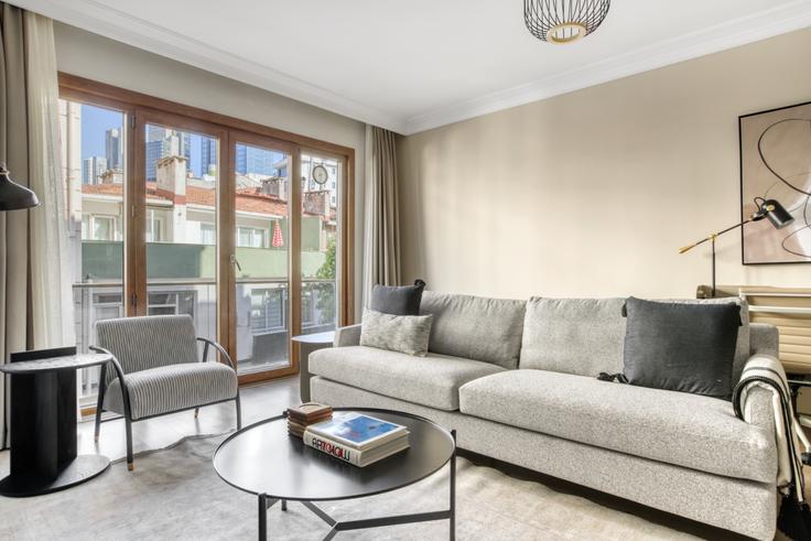 Elegante sala de estar con mobiliario moderno en un apartamento en Huzur Apartmanı - Mecidiyeköy en Şişli, İstanbul Elegante sala de estar con mobiliario moderno en un apartamento en Huzur Apartmanı - Mecidiyeköy en Şişli, İstanbul