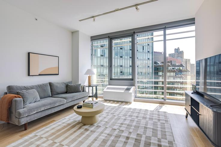 Elegant gestaltetes Wohnzimmer mit moderner Einrichtung in einer Wohnung im Forte Select At Mercedes House in Manhattan, New York Elegant gestaltetes Wohnzimmer mit moderner Einrichtung in einer Wohnung im Forte Select At Mercedes House in Manhattan, New York