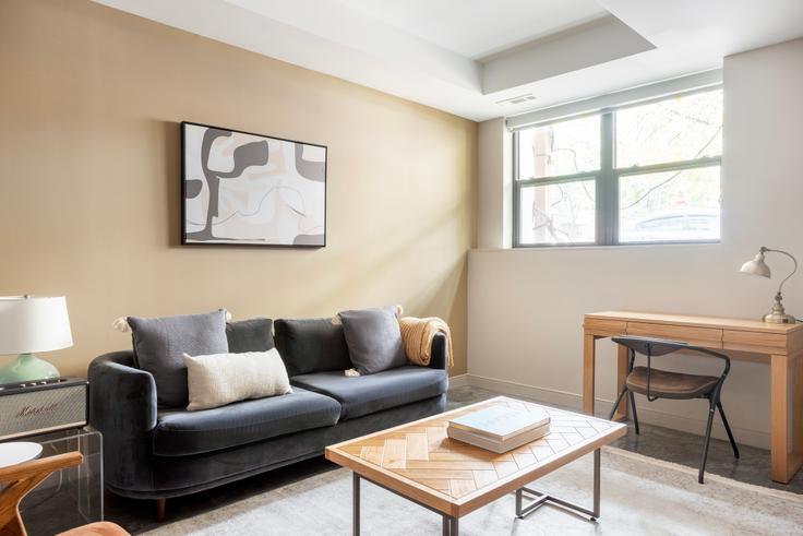 Elegantly designed living room with modern furnishings in an apartment at E3 Edge in Allston, Boston