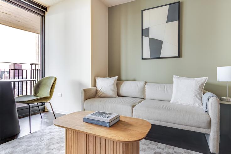 Sala de estar elegantemente projetada com móveis modernos em um apartamento no Aqua em Chicago, Chicago Sala de estar elegantemente projetada com móveis modernos em um apartamento no Aqua em Chicago, Chicago