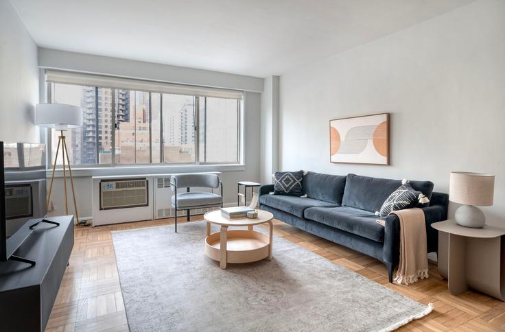 Salle de séjour élégante avec mobilier moderne dans un appartement à Stonehenge 65 à Manhattan, New York Salle de séjour élégante avec mobilier moderne dans un appartement à Stonehenge 65 à Manhattan, New York