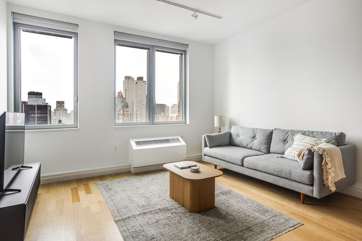 Sala de estar elegantemente projetada com móveis modernos em um apartamento no Forte Select At Mercedes House em Manhattan, New York