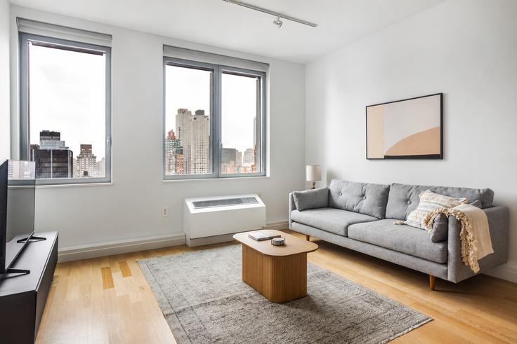 Elegant gestaltetes Wohnzimmer mit moderner Einrichtung in einer Wohnung im Forte Select At Mercedes House in Manhattan, New York Elegant gestaltetes Wohnzimmer mit moderner Einrichtung in einer Wohnung im Forte Select At Mercedes House in Manhattan, New York