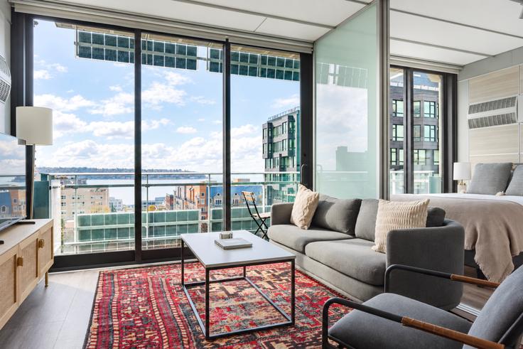 Sala de estar elegantemente projetada com móveis modernos em um apartamento no 3ZERO3 em Seattle, Seattle Sala de estar elegantemente projetada com móveis modernos em um apartamento no 3ZERO3 em Seattle, Seattle