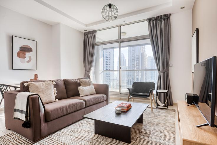 Chic living room with minimalist design from a furnished apartment in Skyview Tower, Dubai