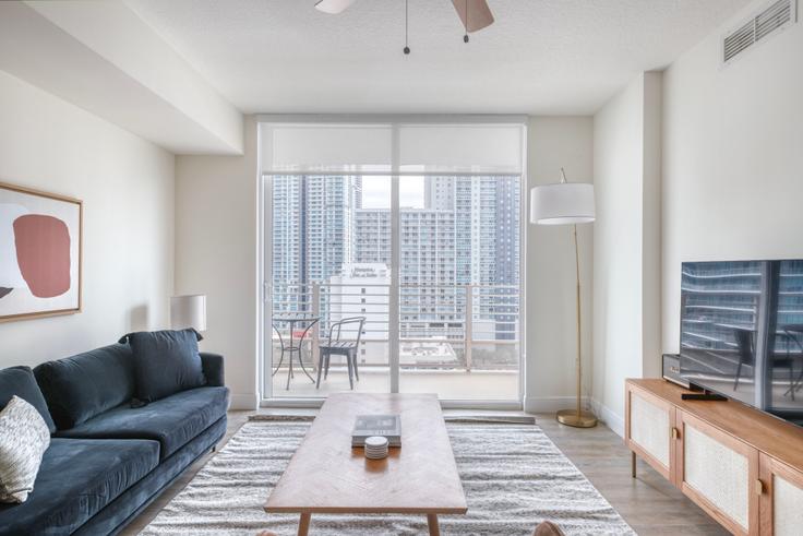 Sala de estar elegantemente projetada com móveis modernos em um apartamento no Brickell First Apartments em Brickell, Miami