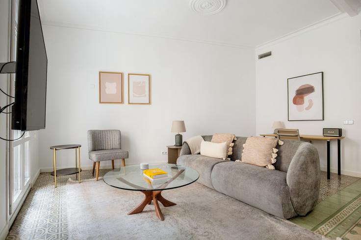 Elegante sala de estar con mobiliario moderno en un apartamento en Tallers 79 en Ciutat Vella, Barcelona Elegante sala de estar con mobiliario moderno en un apartamento en Tallers 79 en Ciutat Vella, Barcelona