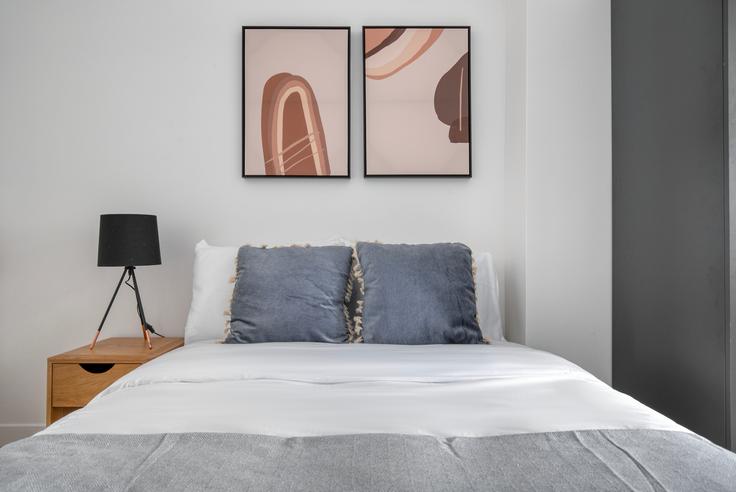 Cozy master bedroom with a large bed, soft lighting, and stylish furniture in a furnished apartment at Delta 12 in 9th arrondissement, Paris