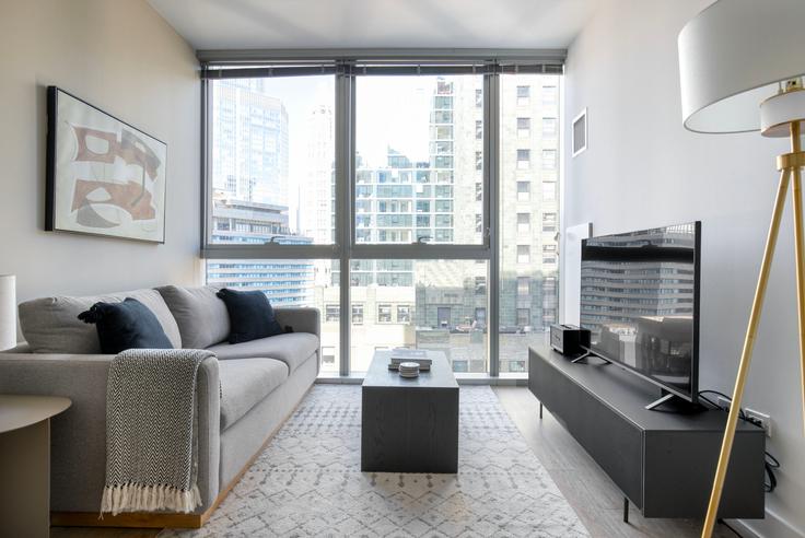 Sala de estar elegantemente projetada com móveis modernos em um apartamento no Mila em Chicago, Chicago